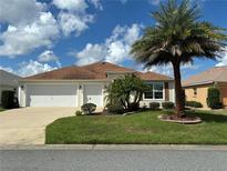 Single-story house with a two-car garage and palm trees at 3732 Barrel Loop, The Villages, FL 32163