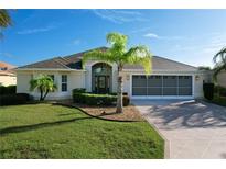 Beautiful single-story home featuring a well-manicured lawn, mature palm trees, and a spacious three-car garage at 1338 Neuport Path, The Villages, FL 32163