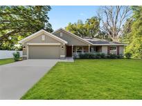Charming single-story home with lush green lawn and well-maintained landscaping, featuring a two-car garage at 8566 Se 156Th Pl, Summerfield, FL 34491