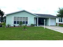 Charming single-story home featuring a well-manicured lawn, complementary landscaping, and an attached single-car garage at 1150 Paradise Dr, The Villages, FL 32159
