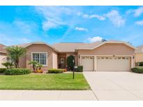 Charming single-story home featuring a well-manicured lawn and a two-car garage at 3506 Mulberry Grove Loop, Leesburg, FL 34748