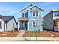 Charming two-story home with a blue exterior, white trim, a green front door and a brick walkway at 3106 Voyager Ave, St Cloud, FL 34771