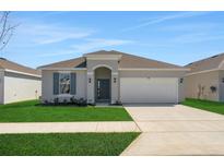 Charming single-story home features a well-manicured lawn and attached two-car garage at 191 Bottle Brush Dr, Haines City, FL 33844