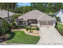 One-story house with nicely landscaped yard and driveway at 414 Carrera Dr, The Villages, FL 32159