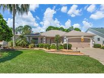 Single-story home with landscaped yard and two-car garage at 414 Carrera Dr, The Villages, FL 32159