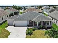 Attractive single-story home with two-car garage, landscaping, and a paved driveway at 736 Jones Ln, The Villages, FL 32163