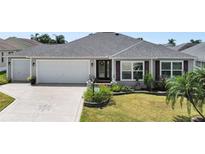 House exterior showcasing a two-car garage and nicely landscaped front yard at 736 Jones Ln, The Villages, FL 32163