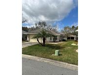 Charming single-story home with a well-manicured lawn, mature landscaping, and a neutral color scheme at 21945 King Henry Ave, Leesburg, FL 34748