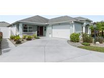Inviting exterior with a two-car garage and well-manicured landscaping at 2968 Wotring Way, The Villages, FL 32163