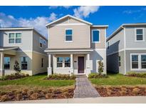 Two-story tan house with a purple door and landscaped lawn at 17036 Clear Mind Aly, Winter Garden, FL 34787