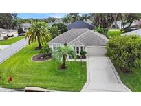 Charming single-story home features beautiful landscaping, palm trees and a well-manicured lawn at 1902 Rosario Rd, Lady Lake, FL 32159