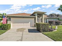 Charming single-story home featuring a well-manicured lawn and an attached two-car garage and beautiful landscaping at 1039 Sandhill St, Groveland, FL 34736