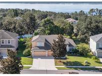 Charming home featuring a well-manicured lawn and inviting curb appeal with view of the lake beyond at 13129 Coldwater Loop, Clermont, FL 34711