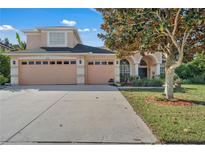 Charming two-story home featuring a three-car garage, mature trees, and meticulously maintained landscaping at 13129 Coldwater Loop, Clermont, FL 34711