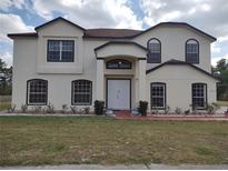 Charming two-story home with a well-manicured lawn, a white exterior, and black trim on the windows and roofline at 18744 Sabal St, Orlando, FL 32833