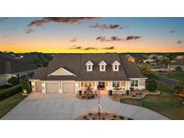 Charming home with a three-car garage, covered porch, and manicured landscaping, ideal for suburban living at 4049 Nostalgia Ter, The Villages, FL 32163