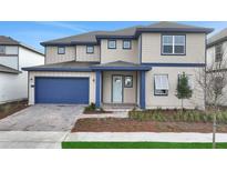 Charming two-story home featuring a blue garage door and trim and a manicured front lawn at 6612 Quest St, St Cloud, FL 34771