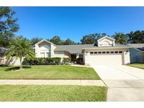 Single-story home with attached garage, landscaping, and a paved driveway at 3109 Timucua Cir, Orlando, FL 32837