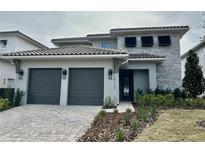 Two-story home with gray double garage and stone accents at 16116 Vetta Dr, Bella Collina, FL 34756