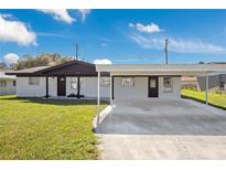 Charming one-story white home with a carport and well-maintained front yard at 2030 Leisure Dr, Winter Haven, FL 33881