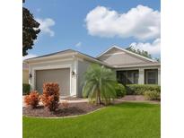 Charming single-story home featuring manicured landscaping and an attached two-car garage at 119 Crescent Moon Dr, Groveland, FL 34736