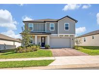 Charming two-story home featuring a brick driveway, two-car garage, and well-manicured lawn at 2298 Raven Ridge Rd, Minneola, FL 34715