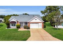 Charming single-story home with a well-manicured lawn and inviting curb appeal at 956 Chula Ct, The Villages, FL 32159