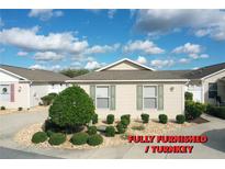 Charming home with a well-manicured front yard featuring lush landscaping and a welcoming entrance at 2339 Nehaul Ter, The Villages, FL 32162