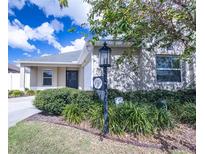 Charming single-story home with lush landscaping and well-manicured lawn at 1967 Ida Ct, The Villages, FL 32163