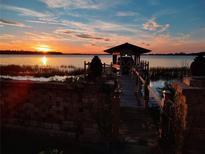 Beautiful sunset view over the lake with a private dock and gazebo, perfect for relaxing and enjoying the scenery at 6118 Dora Dr, Mount Dora, FL 32757