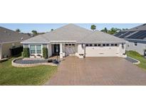 Beautiful single-story home with brick driveway and well-manicured lawn, offering a welcoming curb appeal at 1132 Maynard Path, The Villages, FL 32163