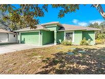 Green house with attached garage and landscaping at 26701 Bimini Dr, Tavares, FL 32778