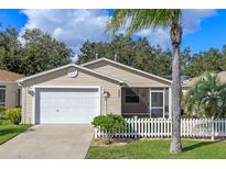 Charming single-story home featuring a two-car garage, screened-in porch, and manicured front lawn at 17478 Se 77Th Sycamore Ave, The Villages, FL 32162