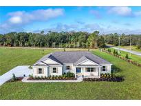 Stunning single-story home with a sprawling front yard and beautiful landscaping at 38805 Ranch Gate Blvd, Umatilla, FL 32784