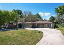 Charming single-story home features a spacious driveway, attached garage, and well-manicured front lawn at 33413 Fairway Rd, Leesburg, FL 34788