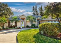 Charming single-story home featuring manicured landscaping, a lush lawn, and a welcoming facade at 33516 Overton Dr, Leesburg, FL 34788
