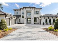 Stunning two-story home boasts a paver driveway and attached three-car garage at 16937 Crete Way, Bella Collina, FL 34756