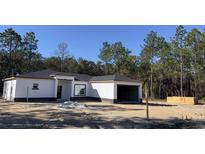 Newly constructed one-story home with attached garage and dark gray roof at 8374 Sw 125Th Ter, Dunnellon, FL 34432