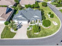 Aerial view of a single-story house with landscaped yard and two-car garage at 1315 Greenville Way, The Villages, FL 32162