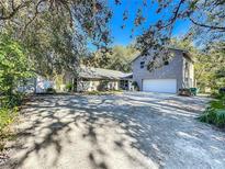 Two-story house with large driveway, attached garage, and mature trees at 1415 E 9Th Ave, Mount Dora, FL 32757