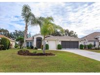 Single-story home with a two-car garage and lush landscaping at 21152 Braveheart Dr, Leesburg, FL 34748