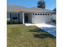 Charming single-story home features a two-car garage, well-maintained lawn, and a welcoming front entrance at 439 Woodview Dr, Tavares, FL 32778