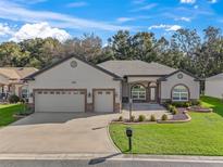 Attractive one-story home with a three-car garage and manicured lawn at 10994 Se 168Th Loop, Summerfield, FL 34491