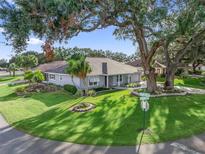 Charming single-story home featuring a well-manicured lawn and mature trees, creating a welcoming curb appeal at 11584 Se 175Th St, Summerfield, FL 34491