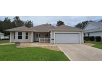 Charming single-story home with well-manicured lawn, rock landscaping, and attached two car garage at 9199 Se 171St Cooper Loop, The Villages, FL 32162