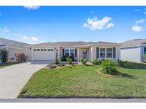 Charming single-story home with a well-manicured lawn, inviting curb appeal, and a two-car garage at 320 Zingale Ln, The Villages, FL 32163