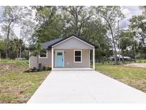 Charming single-story home with a new concrete driveway and a welcoming light blue front door at Lot 17 Indian Estates Cr 423, Lake Panasoffkee, FL 33538