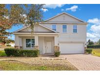Two-story house with a white garage door and stone accents at 11331 Little Nellie Dr, Clermont, FL 34711