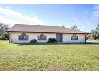 Single-story home with brown roof and landscaped lawn at 26650 Pelican St, Eustis, FL 32736
