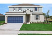 Charming two-story home with a blue garage door and well-maintained lawn at 2833 Supermarine Rd, Tavares, FL 32778